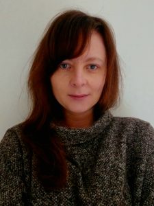 Headshot of lady with brown hair in front of white background